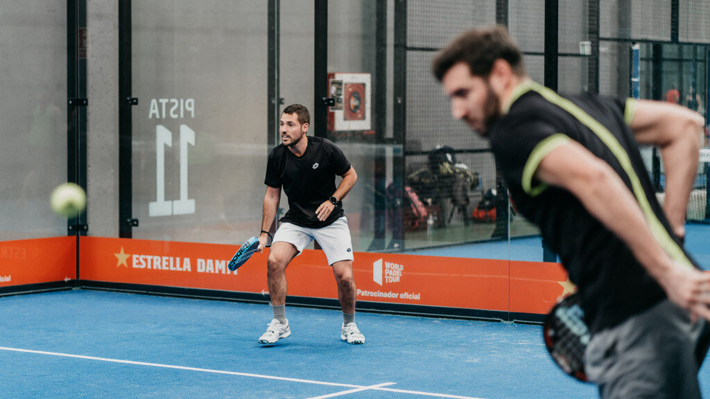 Padel players ready for a low ball during a doubles point